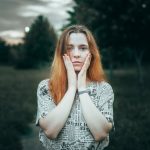 Young woman with hands on cheeks outdoors